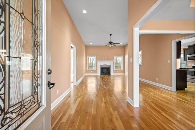 unfurnished living room featuring ceiling fan and light hardwood / wood-style flooring