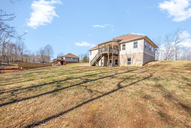 back of house featuring a lawn and a deck