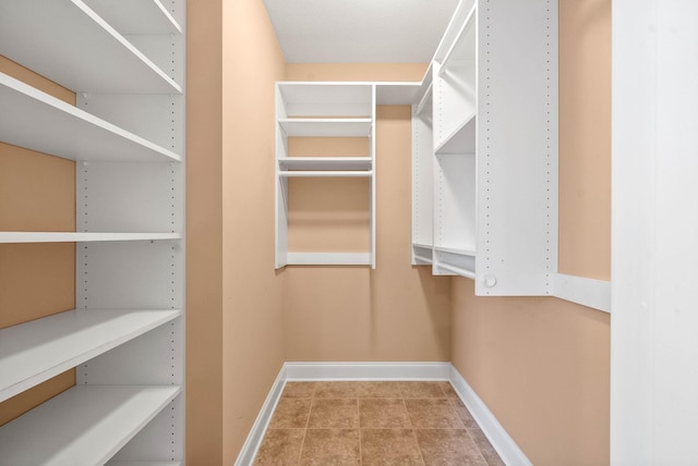 walk in closet with tile patterned flooring