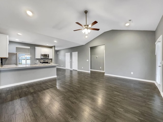 unfurnished living room featuring ceiling fan, dark hardwood / wood-style flooring, and vaulted ceiling