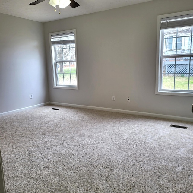 spare room featuring carpet flooring, a wealth of natural light, and ceiling fan