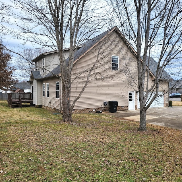 view of side of property with a wooden deck, a garage, and a lawn