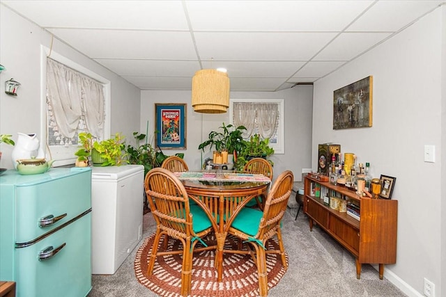 dining room with carpet floors and a paneled ceiling