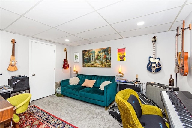 carpeted living room with a paneled ceiling