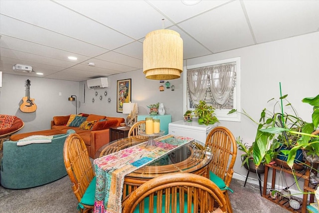 dining space featuring carpet flooring, a paneled ceiling, and a wall unit AC