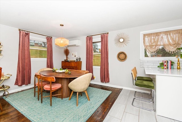 dining room featuring hardwood / wood-style flooring, a healthy amount of sunlight, and a wall unit AC