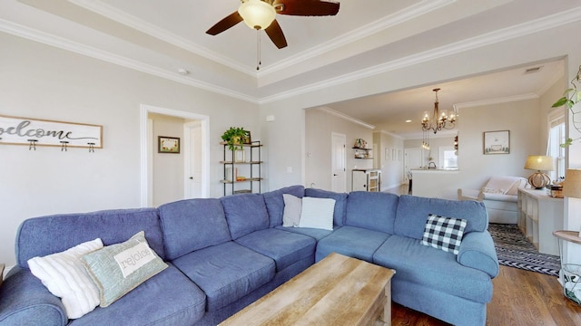 living room with crown molding, dark hardwood / wood-style floors, ceiling fan with notable chandelier, and a tray ceiling