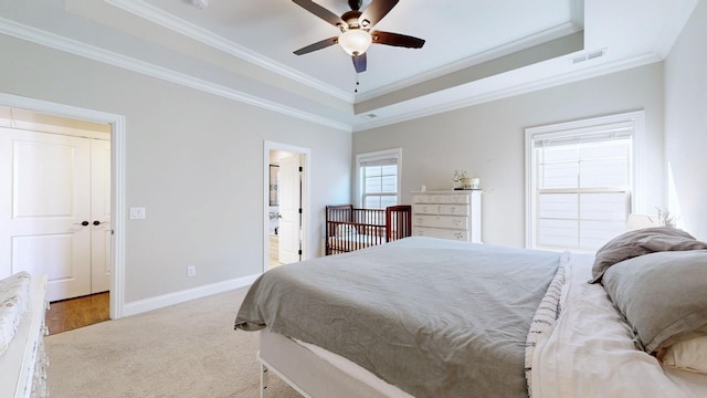 bedroom with crown molding, a tray ceiling, light colored carpet, and ceiling fan