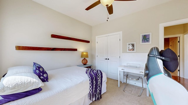 carpeted bedroom featuring ceiling fan and a closet