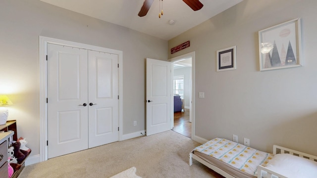 carpeted bedroom with ceiling fan and a closet