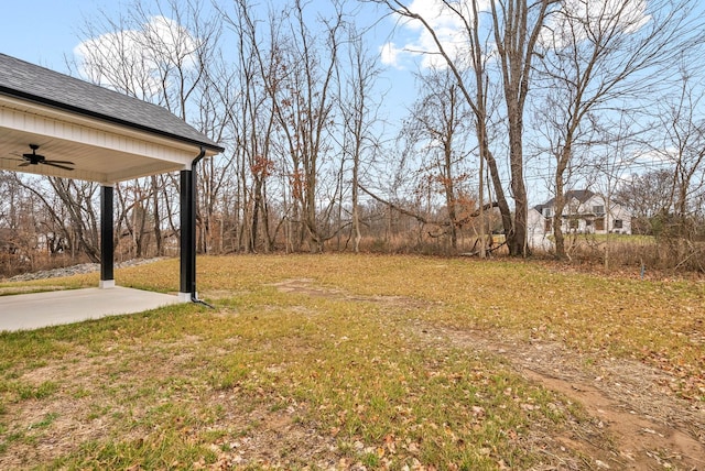 view of yard with ceiling fan and a patio area