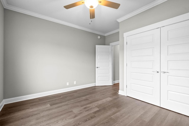 unfurnished bedroom with crown molding, ceiling fan, hardwood / wood-style floors, and a closet