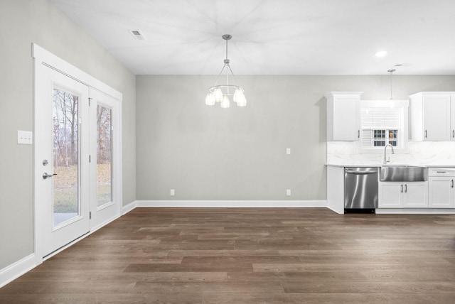 kitchen with white cabinetry, sink, dark hardwood / wood-style flooring, hanging light fixtures, and stainless steel dishwasher