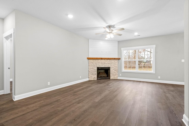 unfurnished living room featuring a fireplace, dark hardwood / wood-style floors, and ceiling fan