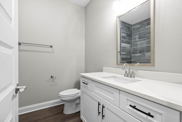 bathroom with wood-type flooring, toilet, and vanity