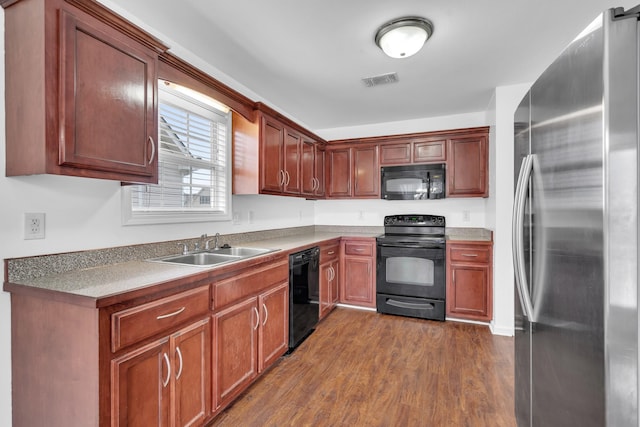 kitchen with sink, black appliances, and dark hardwood / wood-style floors