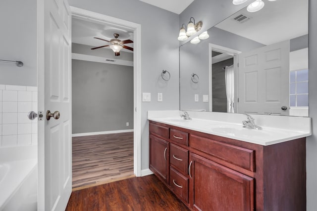 bathroom featuring a tub, ceiling fan, wood-type flooring, and vanity