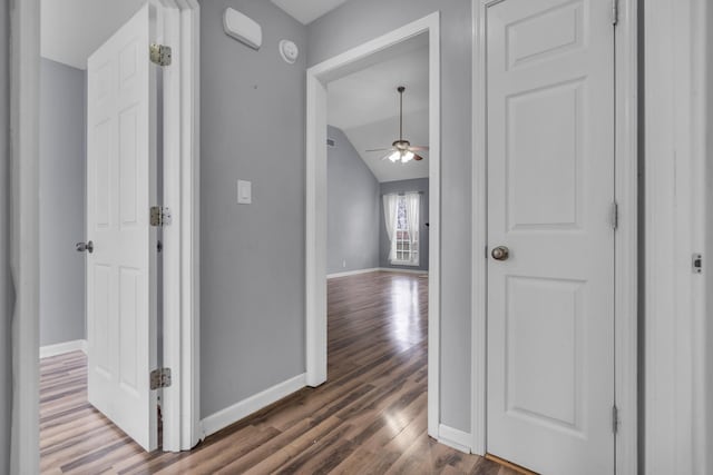 corridor featuring lofted ceiling and dark wood-type flooring