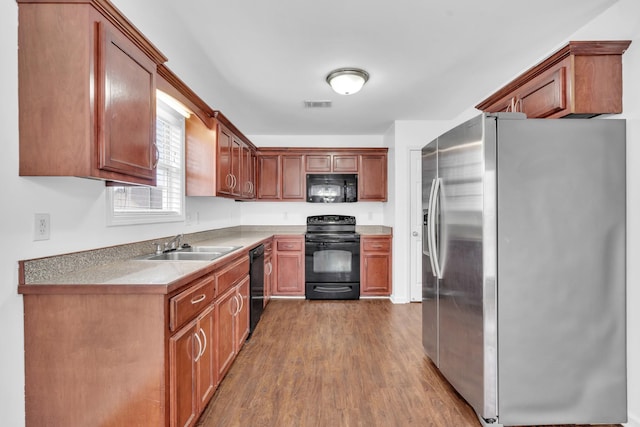 kitchen with sink, black appliances, and dark wood-type flooring