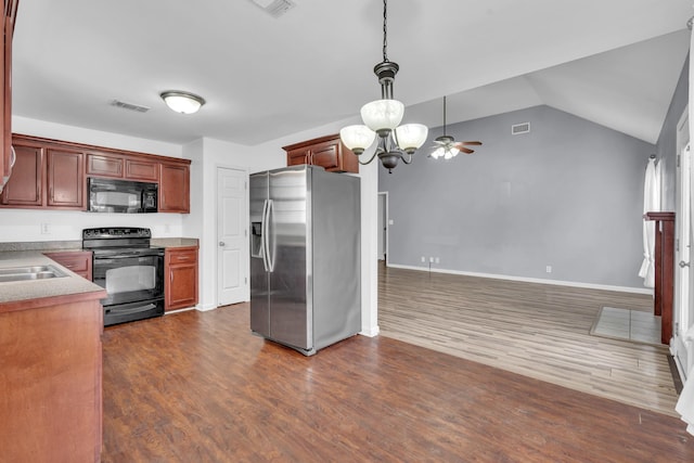 kitchen featuring hanging light fixtures, vaulted ceiling, dark wood-type flooring, and black appliances