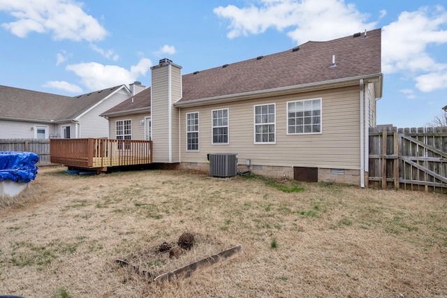 back of house with central air condition unit, a deck, and a lawn