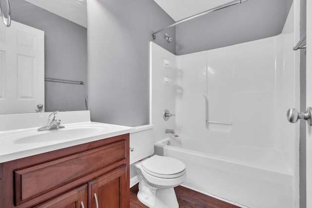 full bathroom with hardwood / wood-style flooring, toilet, vanity, and shower / washtub combination