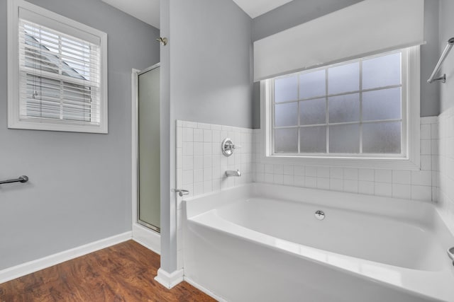 bathroom with independent shower and bath and wood-type flooring