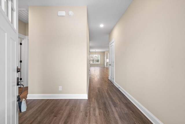 hall featuring dark hardwood / wood-style flooring and a chandelier