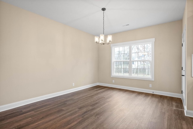 empty room featuring dark hardwood / wood-style floors and a chandelier