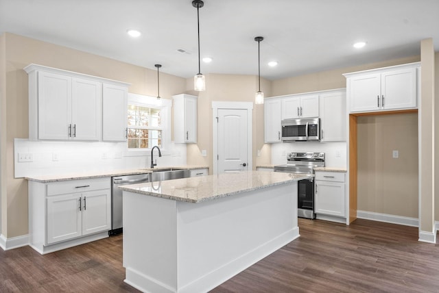 kitchen with white cabinetry, stainless steel appliances, and a kitchen island