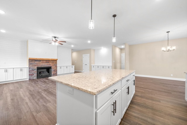 kitchen featuring ceiling fan, hanging light fixtures, dark hardwood / wood-style floors, a center island, and white cabinets