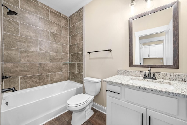 full bathroom featuring wood-type flooring, toilet, vanity, and tiled shower / bath