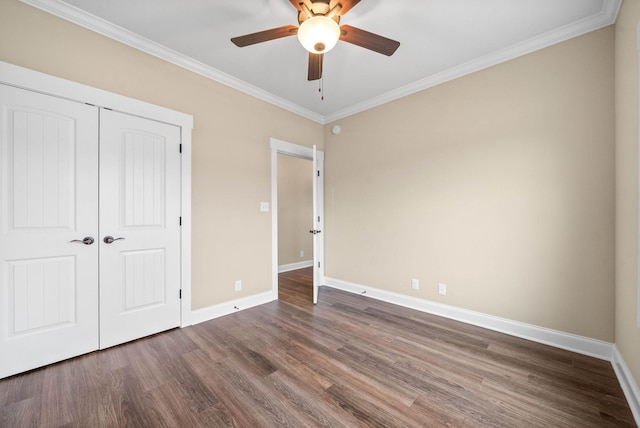 unfurnished bedroom featuring ceiling fan, ornamental molding, dark hardwood / wood-style floors, and a closet