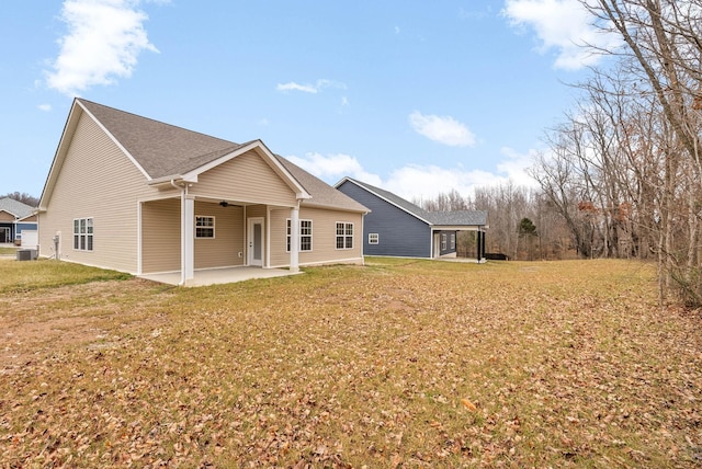 back of house with cooling unit, a lawn, and a patio