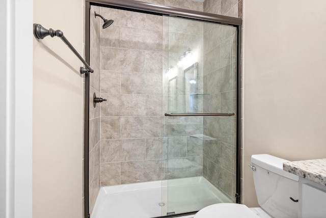 bathroom featuring vanity, toilet, and an enclosed shower