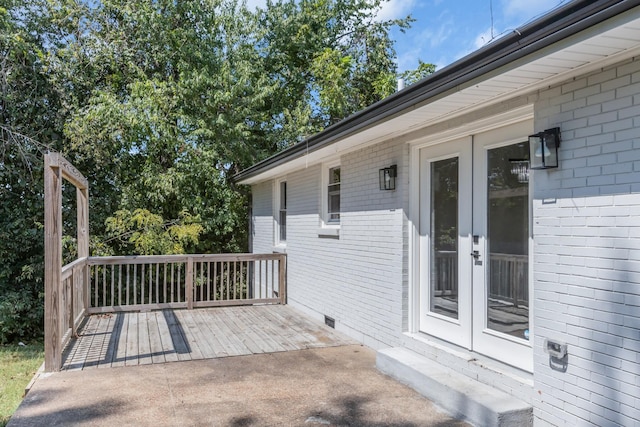 wooden terrace with a patio and french doors