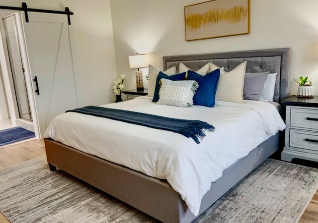 bedroom featuring light hardwood / wood-style flooring and a barn door