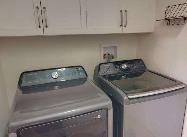 laundry room featuring independent washer and dryer and cabinets