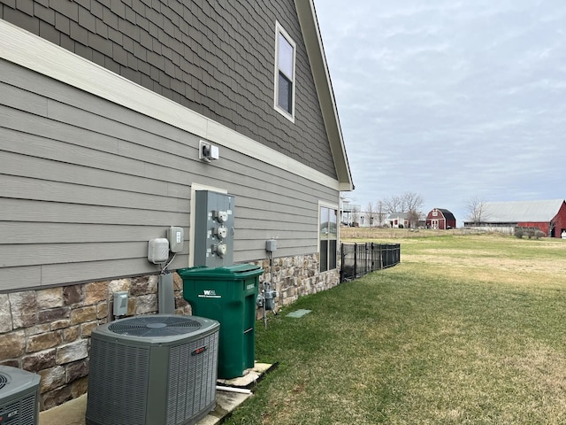 view of property exterior with central AC and a yard