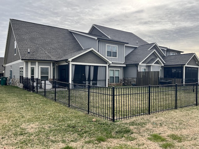 view of front facade with a front yard and a sunroom