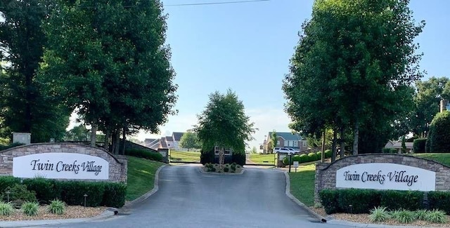 view of street with a gated entry and curbs