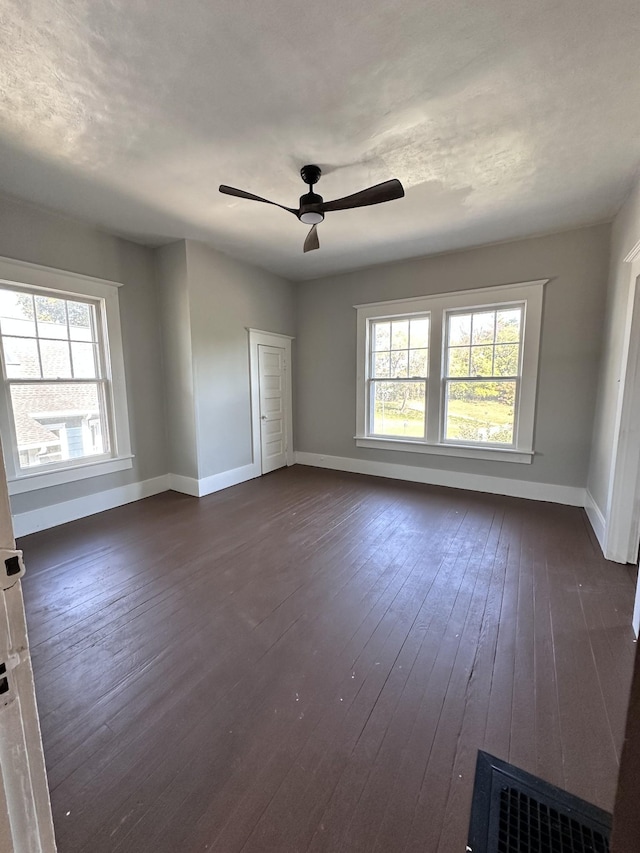 empty room featuring dark wood-type flooring and ceiling fan