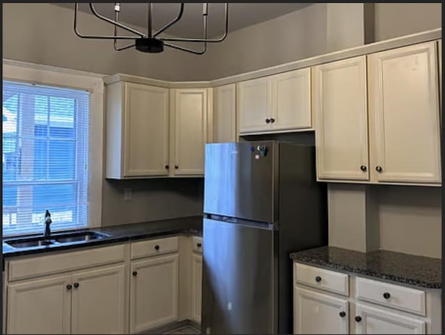 kitchen featuring white cabinetry, sink, and stainless steel fridge