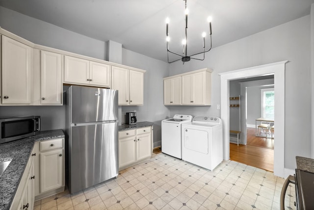 440 N 2nd St, Clarksville, TN 37040 - kitchen featuring stainless steel appliances, washing machine and dryer, a chandelier, and dark stone counters