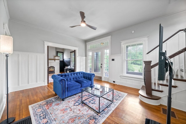 440 N 2nd St, Clarksville, TN 37040 - living area with a decorative wall, wood finished floors, a ceiling fan, stairs, and a wainscoted wall