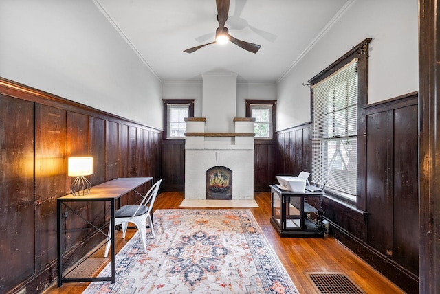 440 N 2nd St, Clarksville, TN 37040 - living area with a wainscoted wall, a ceiling fan, a brick fireplace, wood finished floors, and crown molding