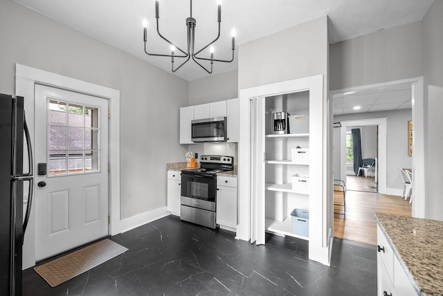 440 N 2nd St, Clarksville, TN 37040 - kitchen featuring stainless steel appliances, white cabinetry, healthy amount of natural light, and light stone counters