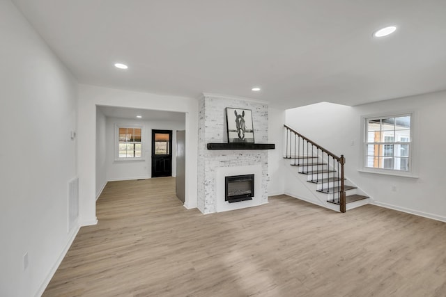 unfurnished living room featuring a fireplace and light hardwood / wood-style flooring