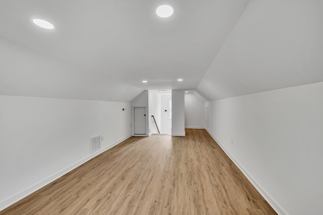 bonus room with lofted ceiling and light wood-type flooring