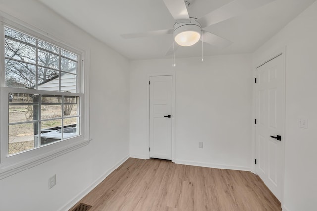 unfurnished room featuring plenty of natural light, ceiling fan, and light wood-type flooring